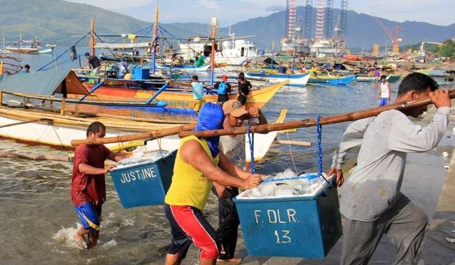 Filipinos unload after coming home to Subic from a fishing expedition in the disputed South China Sea. Photo: EPA