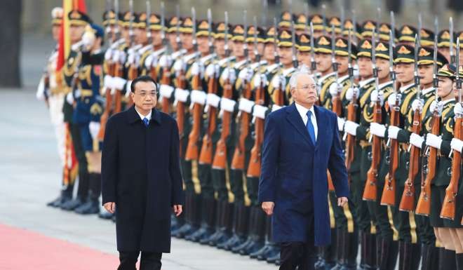 Chinese Premier Li Keqiang escorts Najib Razak, the Malaysian premier, as he receives a guard of honour in Beijing, China. Photo: AFP