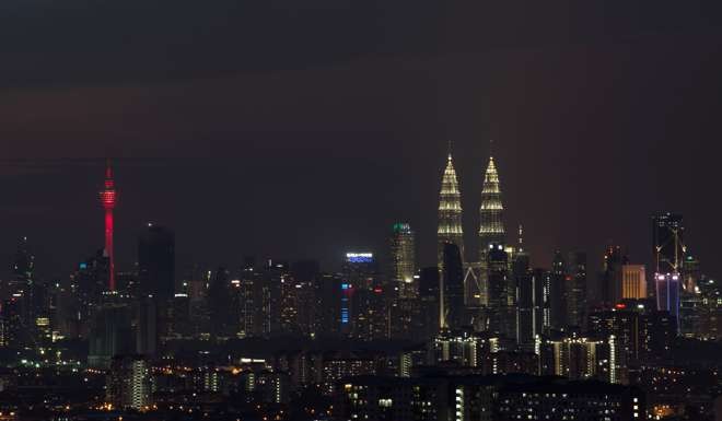 Malaysia’s Petronas Twin Towers and the Kuala Lumpur Tower (red) at night in Kuala Lumpur. Photo: AFP