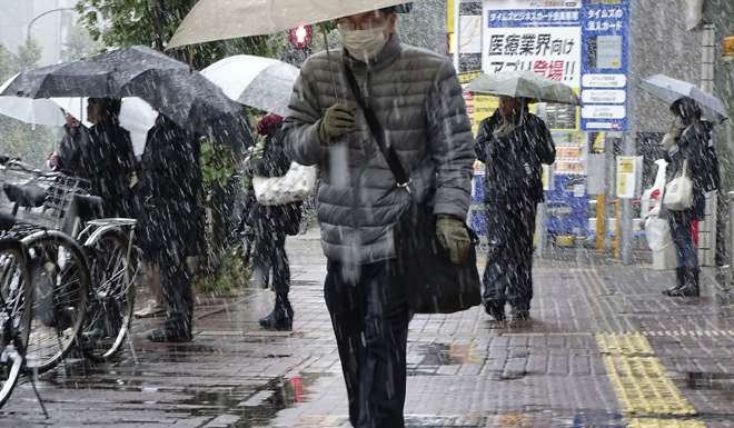 Men walk in the snow in Tokyo. Photo: AP