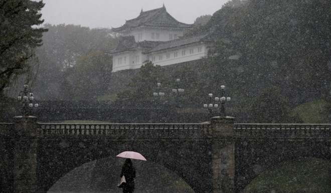A tourist walks near the Imperial Palace in Tokyo. Photo: Reuters