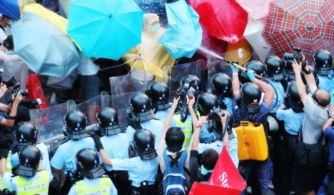 Police use pepper spray on protesters in a still from Raise the Umbrellas. Photo: P. H. Yang