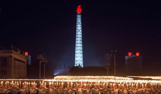 Performers hold burning torches before the Juche tower at Kim Il-Sung square in Pyongyang to mark the 70th anniversary of North Korea’s ruling Workers’ Party. Photo: AFP