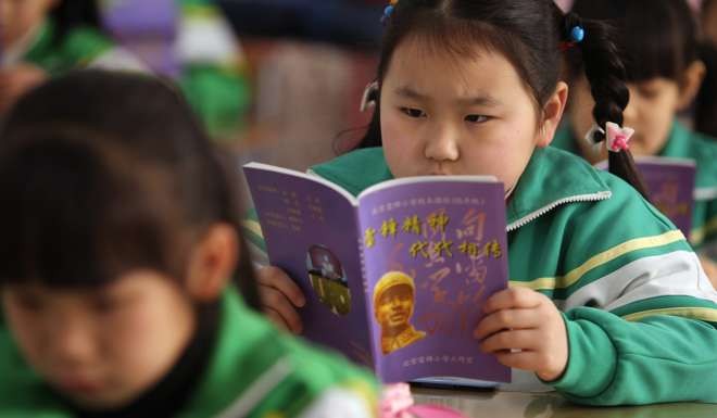 A grade two student reads a text book about Lei Feng at Beijing Leifeng Primary School in Beijing. Photo: Simon Song