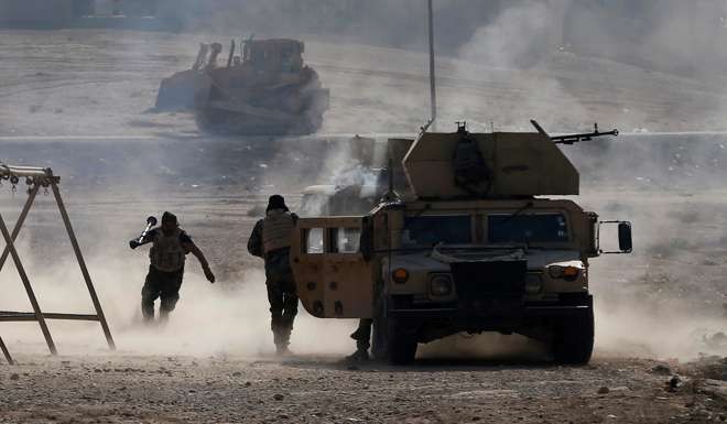 An Iraqi soldier runs for cover after he fires an RPG. Photo: Reuters