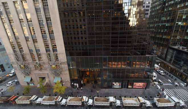 A protective barrier of sanitation trucks are parked in front of Trump Tower to provide security for the president-elect. Photo: AFP