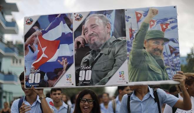 Young Cubans hold pictures of Fidel Castro. Photo: AP
