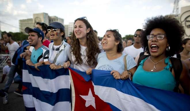 Participants hold Cuban flags as they rally in Havana. Photo: AP