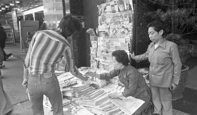 A man purchasing a newspaper at a newspaper stand in Mongkok in 1977. Photo: SCMP Pictures