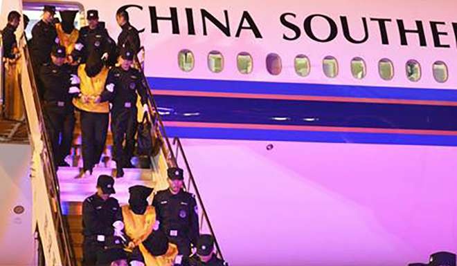 The suspects leave the plane at Wuhan airport. Photo: SCMP Pictures
