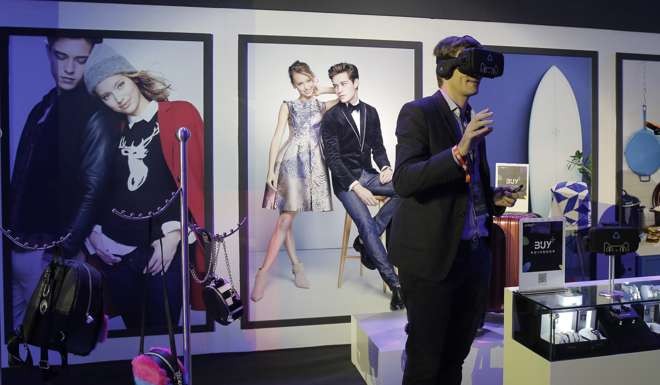 A man tries out a headset offering “augmented reality” at an exhibition during the “Singles’ Day” global online shopping festival in Shenzhen. The Chinese government sees the internet as a new engine of growth, and is pushing hard to develop related industries such as e-commerce. Photo: AP