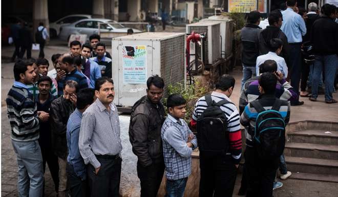 People queue to draw cash from ATM booths in New Delhi on Wednesday. Three weeks after the demonetisation move, queues at ATMs and outside banks to withdraw money are still very long. Photo: Xinhua