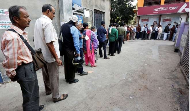 People queue outside a bank to withdraw cash and deposit their old high-denomination notes in Calcutta on Wednesday. Photo: Reuters