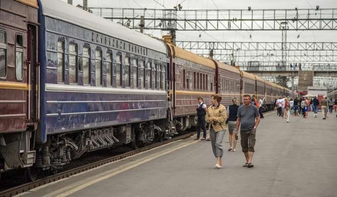 Passengers stroll on a platform beside the Tsar's Gold train on the Trans-Siberian Railway.