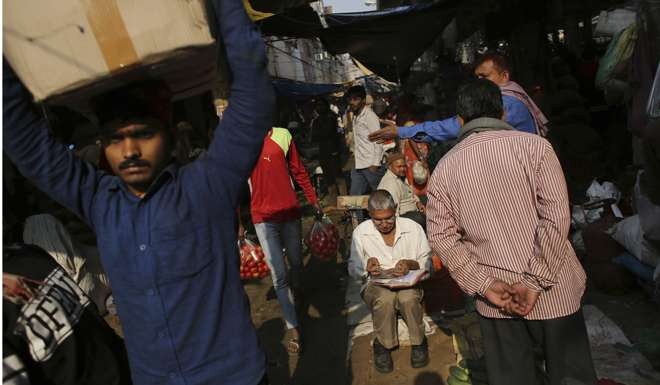 A trader counts money at Azadpur Mandi, one of Asia’s largest wholesale fruit and vegetable markets in New Delhi. The impact of the banknote ban cannot be overstated – 90 per cent of the transactions in India use cash. Photo: AP