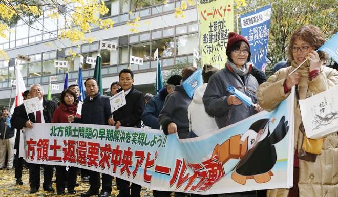People stage a demonstration in Tokyo, seeking the return of four Russian-held islands off Hokkaido ahead of a summit between Russian President Vladimir Putin and Japanese Prime Minister Shinzo Abe in mid-December. Photo: Kyodo
