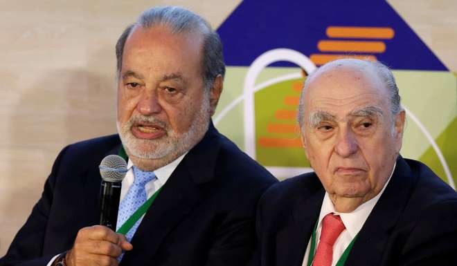 Mexican billionaire Carlos Slim (L) speaks beside former president of Uruguay Julio Maria Sanguinetti. Photo: Reuters