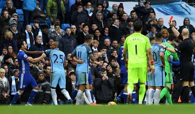 English referee Anthony Taylor (R) shows a red card to Manchester City's Brazilian midfielder Fernandinho (2R) as he grabs Chelsea's Spanish midfielder Cesc Fabregas. AFP