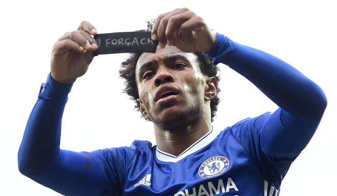 Chelsea's Brazilian midfielder Willian holds up his black armband dedicated to the Chapeconse plane crash victims as he celebrates scoring his team's second goal . AFP