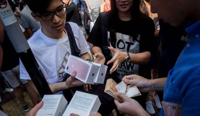 Parallel traders make the most of the opening day of sales for the latest iPhone, outside an Apple store in Hong Kong on September 16. Photo: AFP