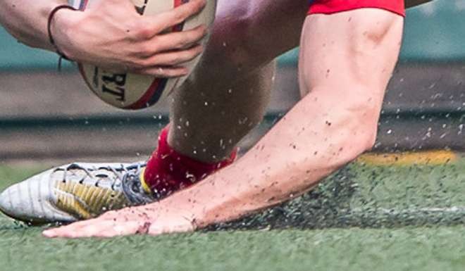 Rubber crumbs fly during a rugby match on astroturf. Photo: SCMP Pictures