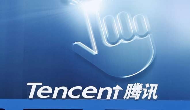 Dancers perform underneath the logo of Tencent at the Global Mobile Internet Conference in Beijing. Photo: Reuters