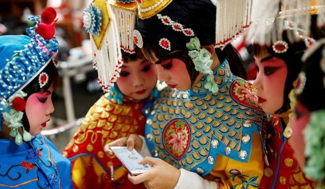 A contestant at a Chinese opera competition at the National Academy of Chinese Theatre Arts in Beijing last month plays a game on her phone during a break. The Chinese mobile game scene has reached a new level of maturity, with high-quality, original mobile games released at an astonishing rate. Photo: Reuters