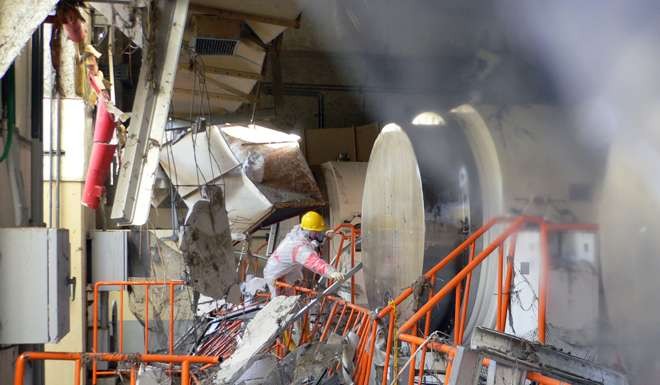 A worker removes debris at the dry cask storage building at the Fukushima Dai-ichi nuclear plant at Okuma town in Fukushima prefecture. Photo: AFP