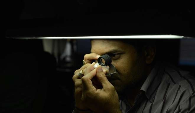 A technician inspects a rough diamond at a manufacturing company in Surat, some 270 kms from Ahmedabad. Photo: AFP