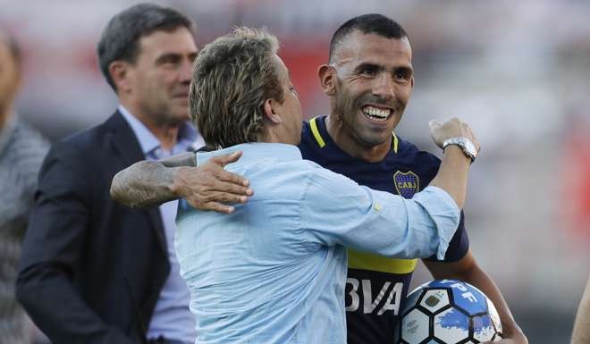 Boca Juniors' forward Carlos Tevez smiles as he is congratulated and the end of the Argentine soccer derby against River Plate, in Buenos Aires, Argentina, Sunday, Dec. 11, 2016. Boca defeated River 4-2. (AP Photo/Victor R. Caivano)