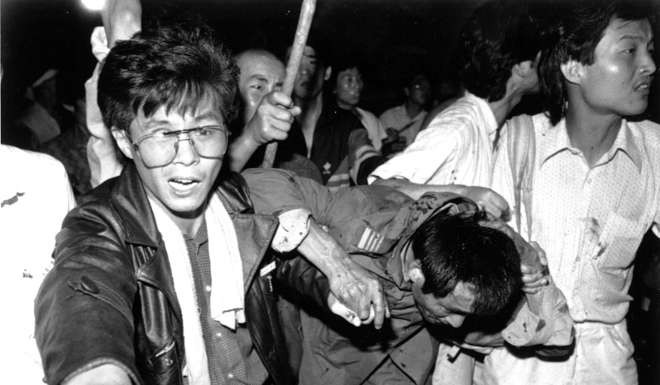 Students in Tiananmen Square help a captured tank driver to safety on June 4, 1989 after the crowd beat him. The bloody events of that day ripped Ha Jin’s world in half. Photo: Reuters