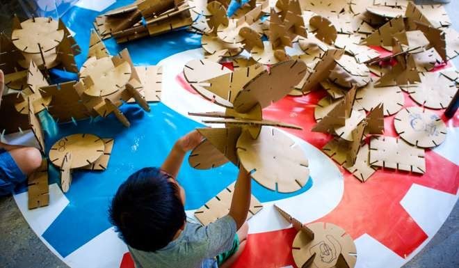 A child plays with cardboard at Makerbay, PMQ, Central.