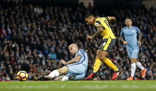 Arsenal’s Theo Walcott scores the first goal goal of the match. Photo: Reuters