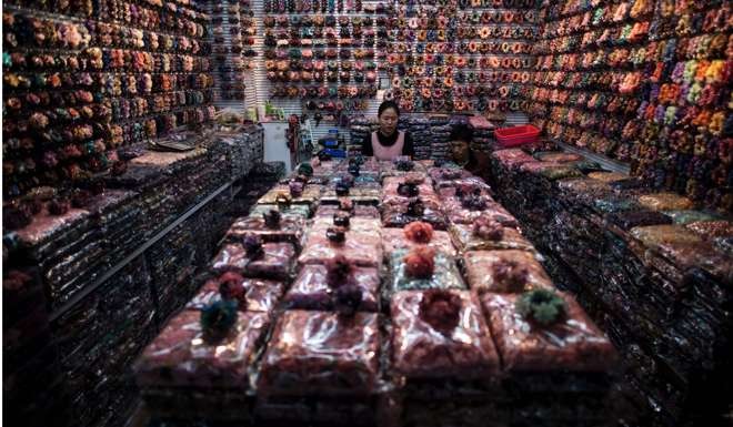 A vendor sits in her booth at the Yiwu wholesale market in Zhejiang province. Both China and the US must seize the numerous opportunities for economic cooperation. Photo: AFP