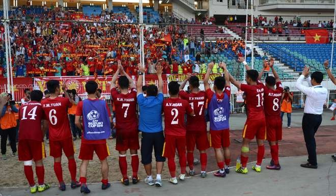 The Vietnam squad greets fans following their 1-0 victory against Malaysia during the AFF Suzuki Cup group match in Yangon in November. Photo: AFP