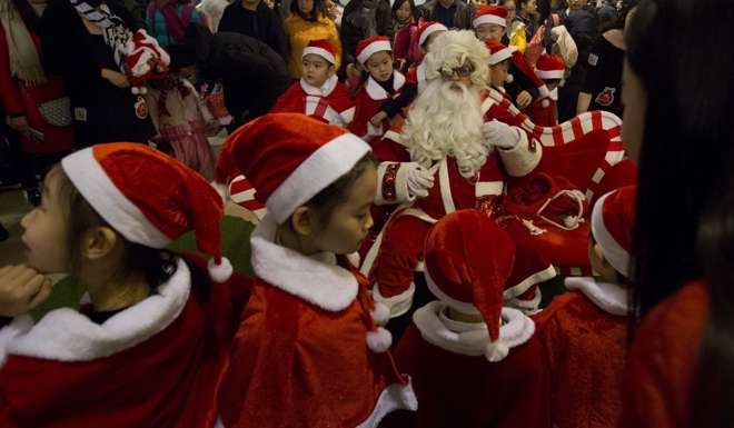 Children dressed as Santa's elves in a shopping mall in Beijing, China. Photo: AP