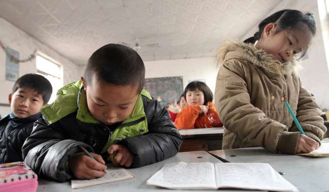 Pupils do their homework in class at the Xiangyang Primary School in Beijing’s Daxing district. Photo: Simon Song