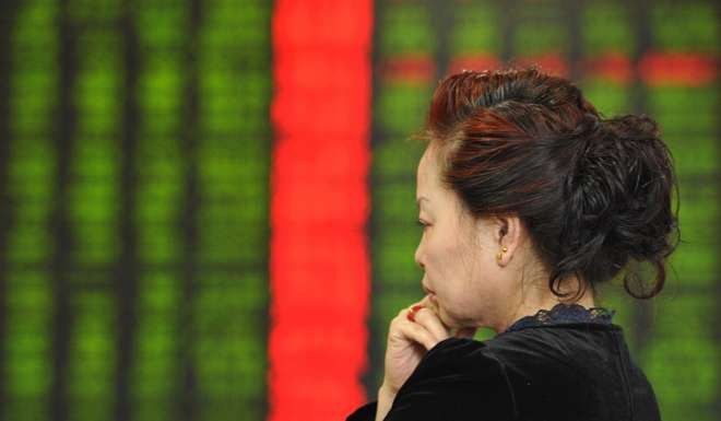 An investor standing in front of a screen showing stock market movements at a securities firm in Fuyang in eastern China's Anhui province. Photo: AFP