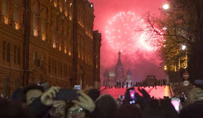 People take photos of fireworks above the Red Square in Moscow, Photo: Xinhua