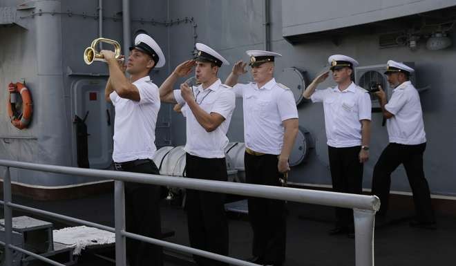 Members of the Russian Navy salute on board the Admiral Tributs. Photo: AP