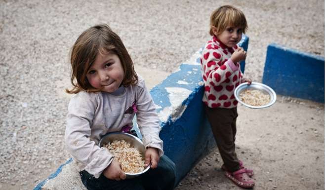 Syrian children at the Ritsona refugee camp, some 80km north of Athens, eat a meal cooked by chef Talal Rankoussi and volunteers on December 21. Before braving a “trip of death” to escape Syria, Talal was a chef in a Damascus restaurant considered the largest in the world. Photo: AFP