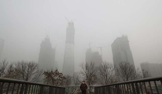 Thick, grey smog hangs over Beijing on Wednesday, clouding China's capital in a haze that spurred authorities to cancel flights and close some highways in emergency measures to cut down on air pollution. Photo: AP