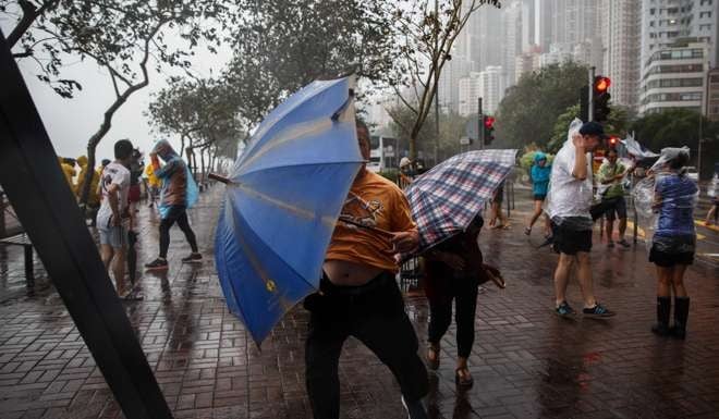 October’s typhoon Haima brought mostly deserted streets and driving wind and rain, but thrill seekers couldn’t resist a stroll in the heavy weather. Photo: AFP