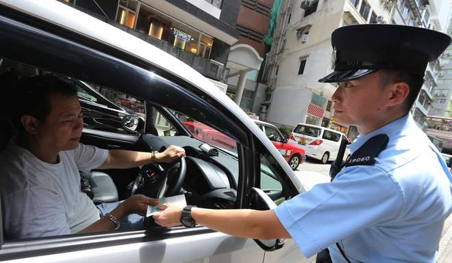 A police officer hands out an illegal parking ticket in Central on June 1 last year. The HK$320 fixed penalty, unchanged since 1994, works out at little more than a cheap parking charge. Photo: Dickson Lee