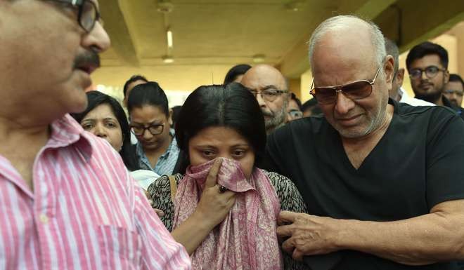 Nandita Puri (centre), wife of award-winning character actor Om Puri, is consoled by relatives as she leaves the hospital in Mumbai on January 6, 2017. Photo: AFP