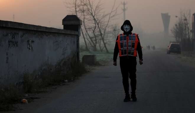 Artist Liu Bolin wears a vest with 24 mobile phones as he live broadcasts air pollution in Beijing last month. Photo: Reuters