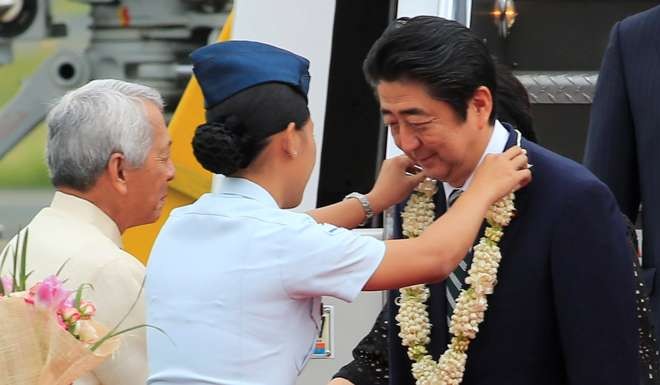Japanese Prime Minister Shinzo Abe receives a garland upon his arrival for a state visit in metro Manila. Photo: Reuters