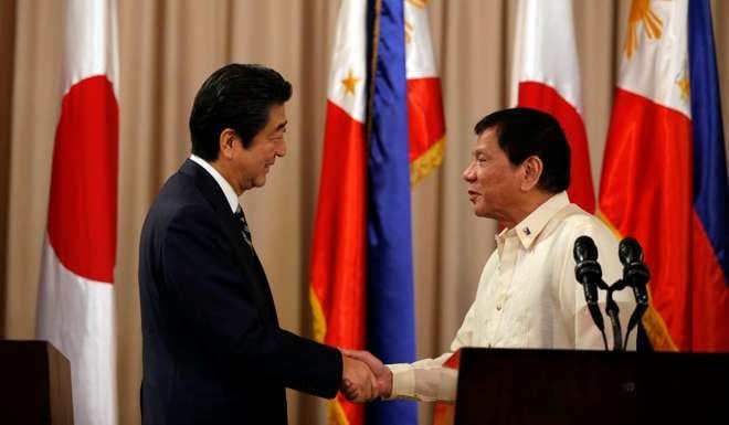 Philippine President Rodrigo Duterte and visiting Japanese Prime Minister Shinzo Abe shake hands after a joint statement at the presidential palace in Manila. Photo: Reuters