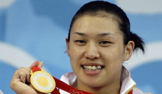 Cao Lei holds up her gold medal at the Beijing Olympics. Photo: AP