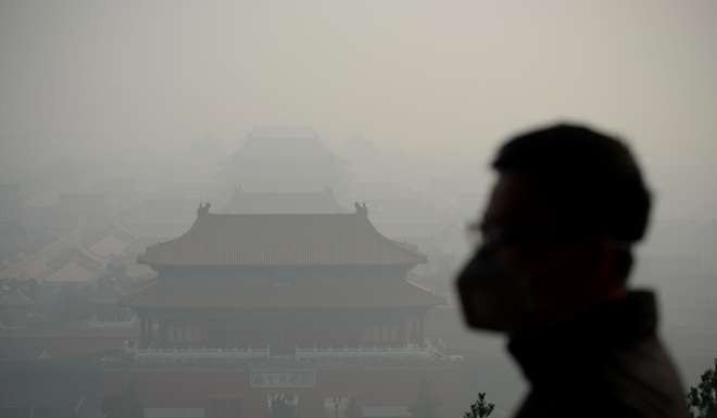 Face masks to the fore during a visit by this tourist to the Forbidden City in November. Photo: